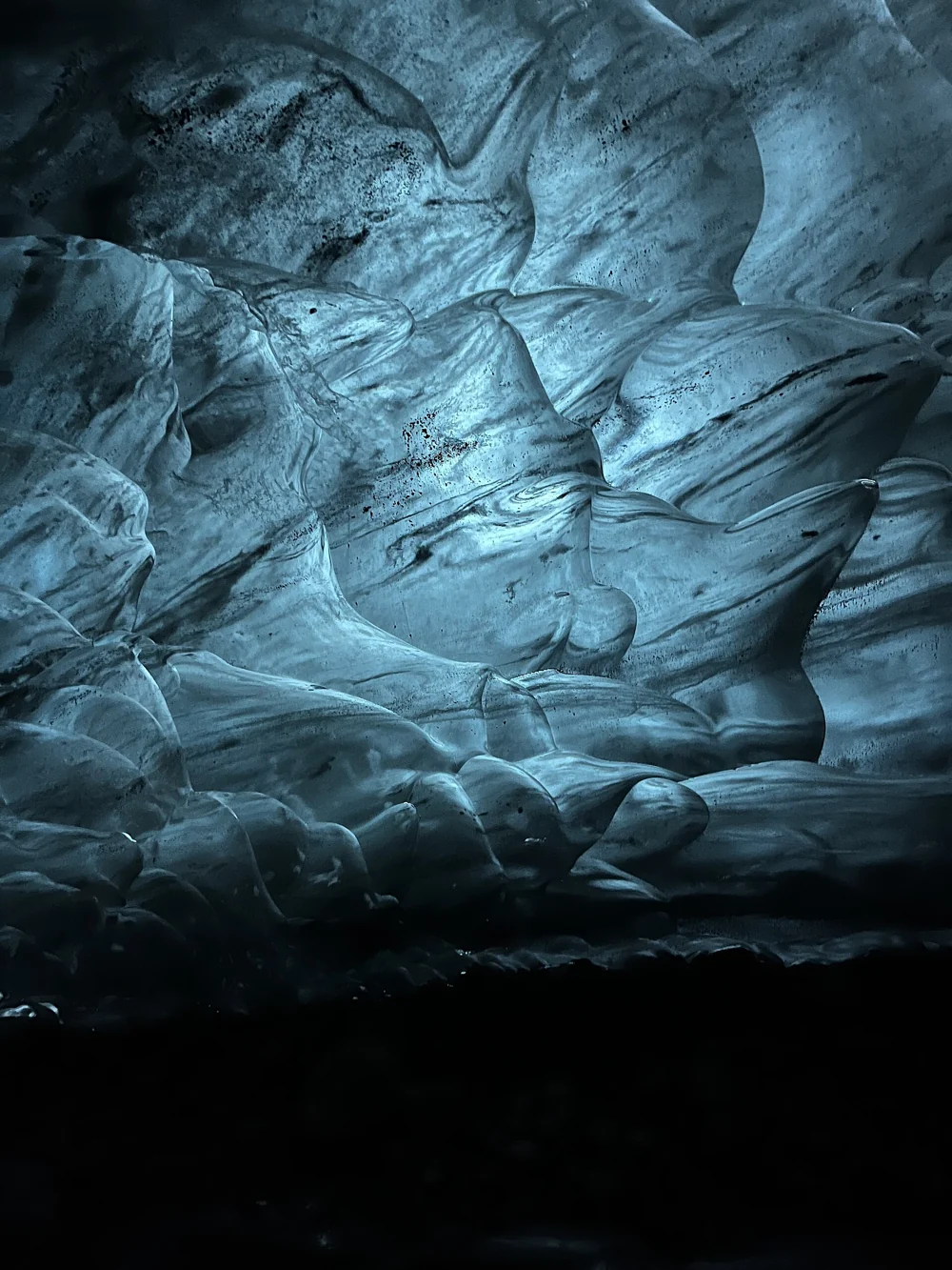 Sunlight setting the scalloped wall of a Vatnajökull ice cave aglow near Höfn on an Iceland ice cave day tour